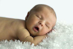 Новорожденный ребенок спит на животике